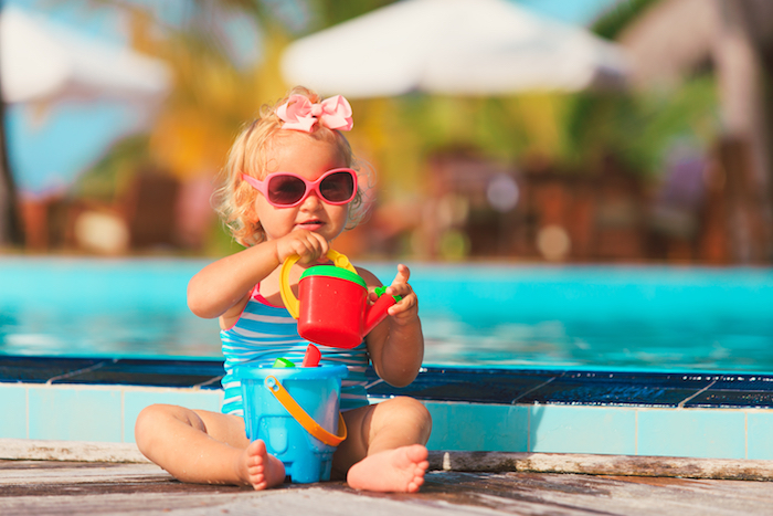 Une petite fille qui joue au bord de la piscine